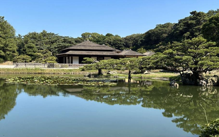 Ritsurin A pond and a building in the background.
